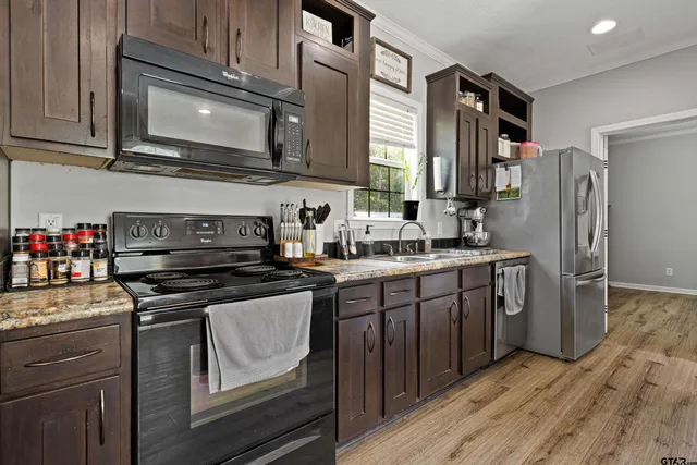 a kitchen with stainless steel appliances granite countertop a refrigerator stove and sink