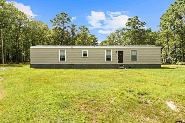 a view of a house with a backyard