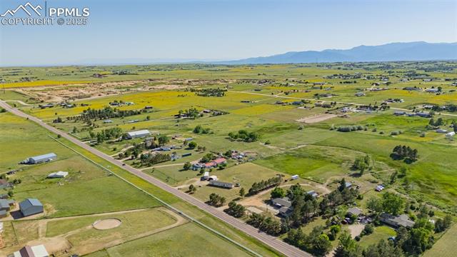 6010 Curtis Road Peyton, CO 80831 - Photo 39 of 42 Aerial view of property and surrounding area with a mountainous background and rural landscape
