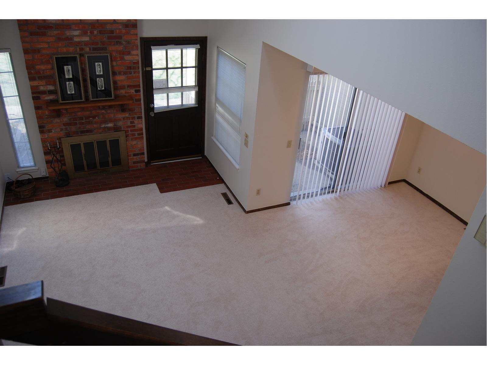 a view of an empty room with window and fireplace