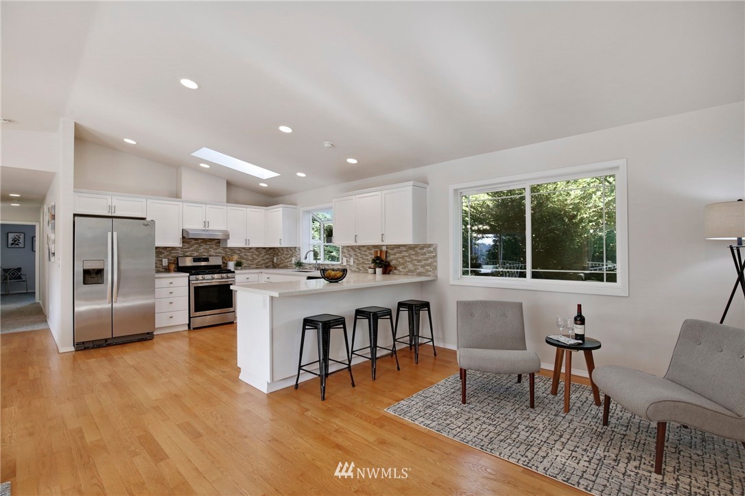 801 Southwest 3rd Place Renton, WA 98057 - Photo 15 of 28 a open kitchen with stainless steel appliances granite countertop a stove top oven a sink dishwasher a dining table and chairs with wooden floor