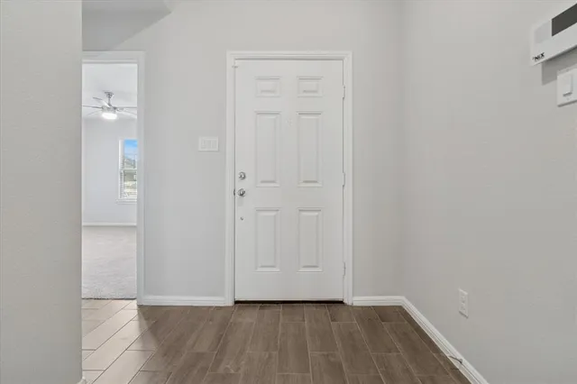 a view of an empty room with wooden floor