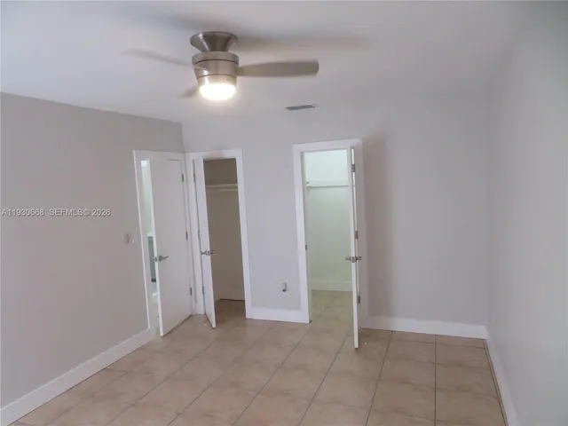 a view of a brick house with a small yard and wooden fence