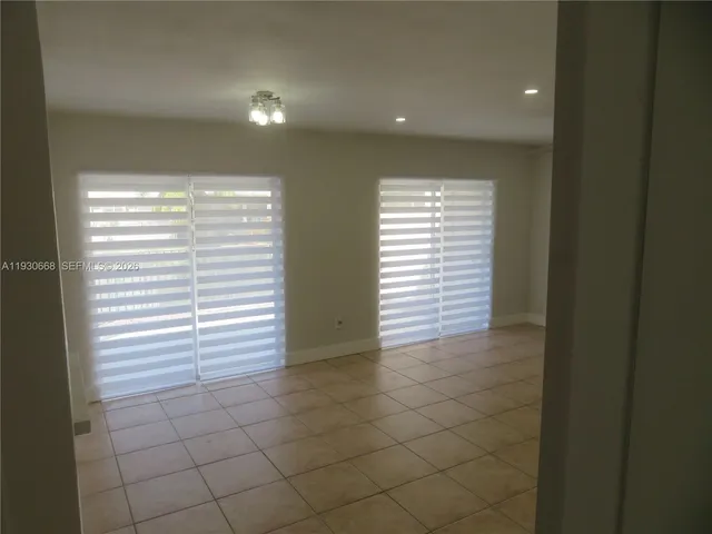 wooden floor in an empty room with a bathroom