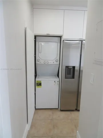 a room with a refrigerator and wooden floor