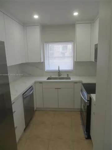 a kitchen with a sink cabinets and window