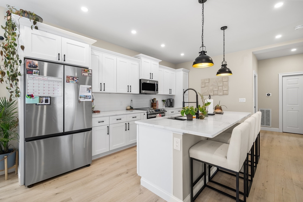 40 Bates Road Framingham, MA 01702 - Photo 1 of 25 a kitchen with refrigerator cabinets and wooden floor