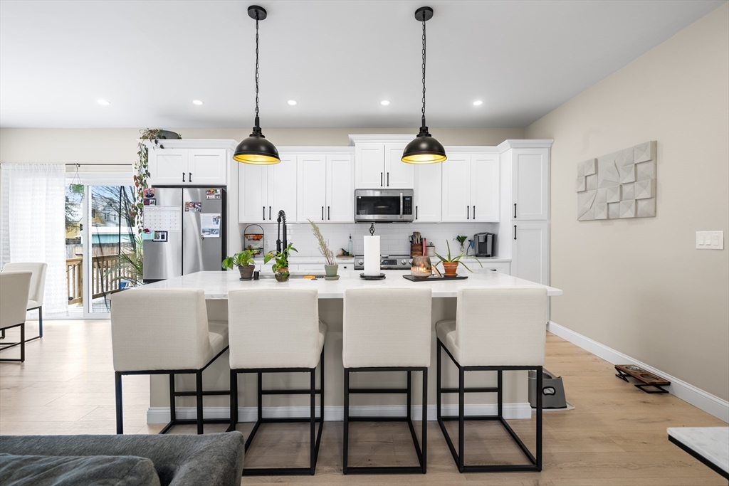 40 Bates Road Framingham, MA 01702 - Photo 6 of 25 a kitchen with stainless steel appliances kitchen island granite countertop a table chairs and white cabinets