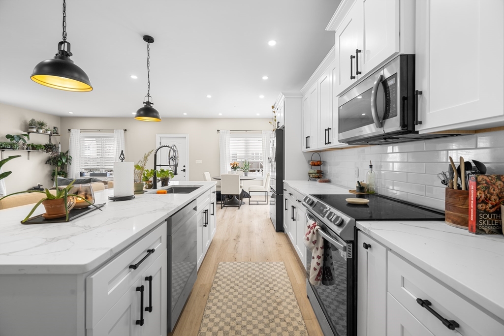 40 Bates Road Framingham, MA 01702 - Photo 8 of 25 a kitchen with stainless steel appliances granite countertop a sink a stove and a wooden floors