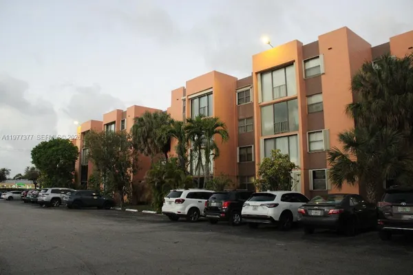 a couple of cars parked in front of a building