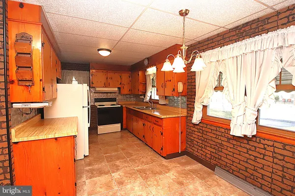 a kitchen with stainless steel appliances granite countertop a sink a stove and a refrigerator