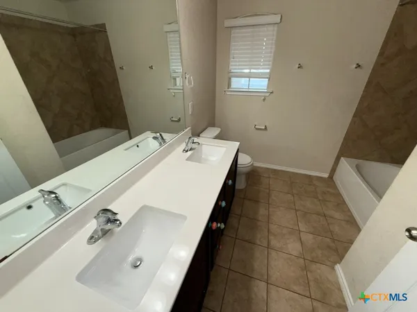 a bathroom with a sink a toilet and mirror