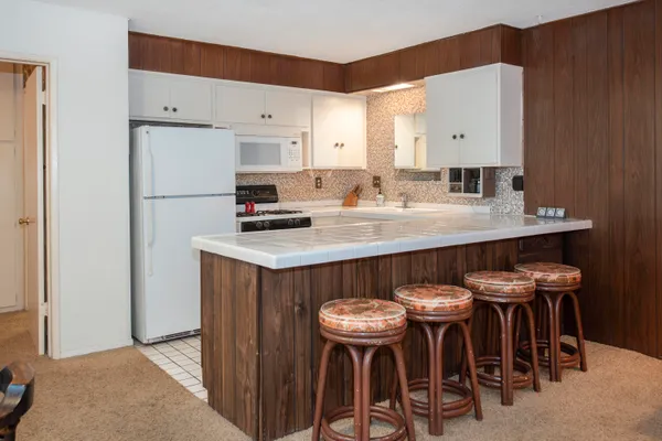 a kitchen with stainless steel appliances a table and chairs