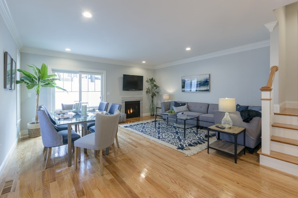 a living room with furniture a fireplace and a potted plant