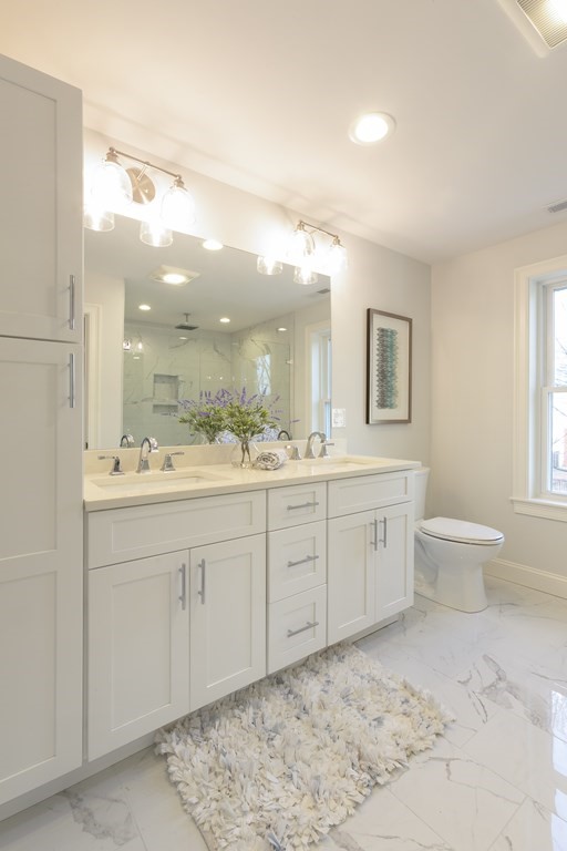 211 West Street, Unit 211 Needham, MA 02494 - Photo 21 of 29 a spacious bathroom with a granite countertop sink a toilet and a mirror