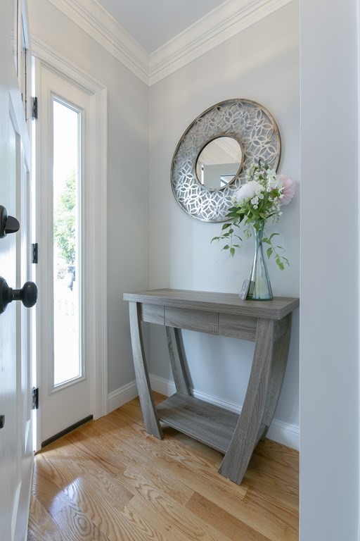 211 West Street, Unit 211 Needham, MA 02494 - Photo 4 of 29 a view of a hallway with entryway wooden floor and a chandelier