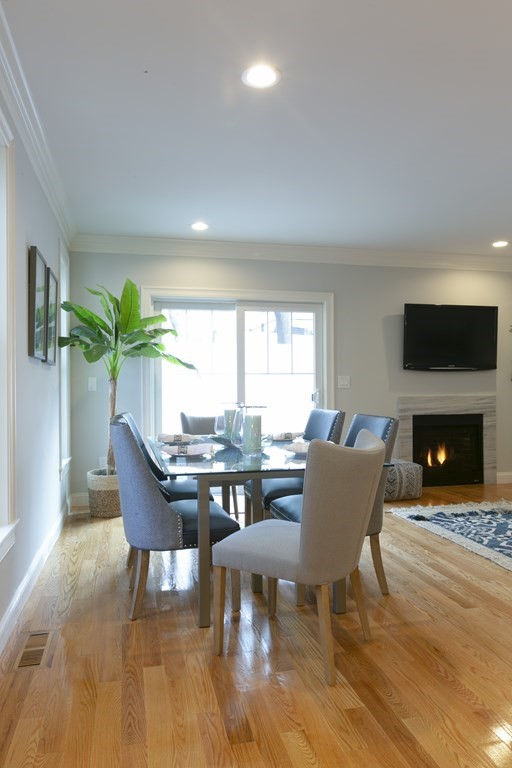 211 West Street, Unit 211 Needham, MA 02494 - Photo 9 of 29 a dining room with furniture a fireplace and wooden floor