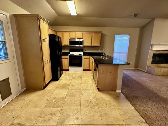 a kitchen with stainless steel appliances a refrigerator a stove a sink and a refrigerator