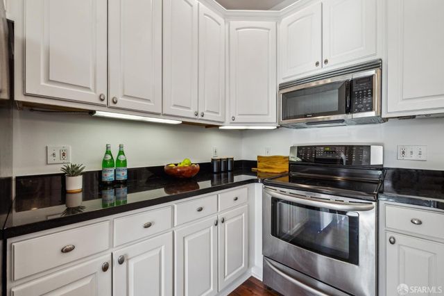 a kitchen with white cabinets and appliances