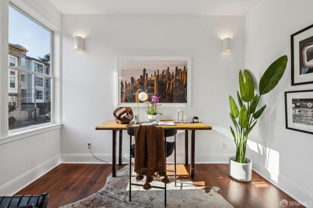 a dining room with furniture potted plants and wooden floor