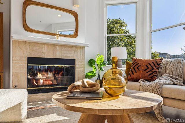 a living room with furniture a fireplace and a large window