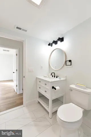 a bathroom with a toilet sink and mirror