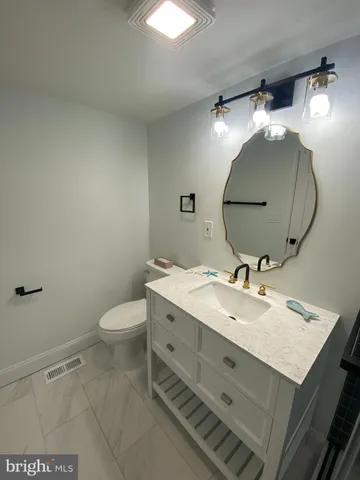 a bathroom with a sink mirror vanity and toilet