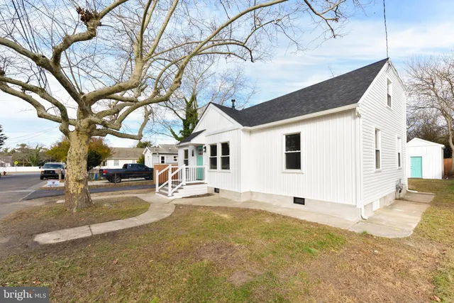 a view of a white house with a large tree