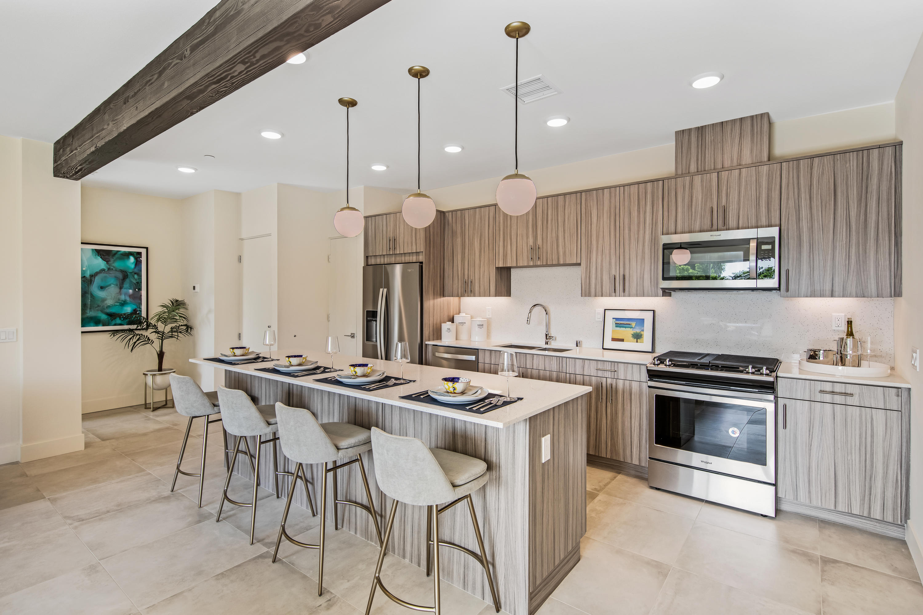 161 The Riv Palm Springs, CA 92262 - Photo 2 of 15 a kitchen with stainless steel appliances kitchen island a table chairs sink and stove top oven