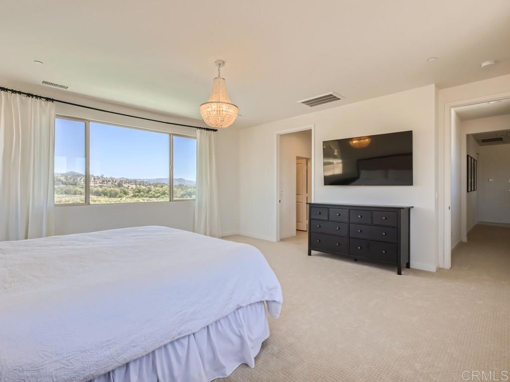 31657 Calle De Las Estrellas Bonsall, CA 92003 - Photo 15 of 24 a spacious bedroom with a bed and a flat screen tv