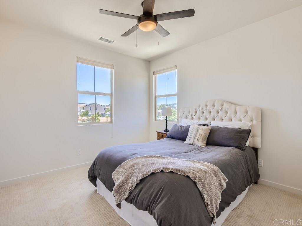 31657 Calle De Las Estrellas Bonsall, CA 92003 - Photo 18 of 24 a bedroom with a large bed and a chandelier