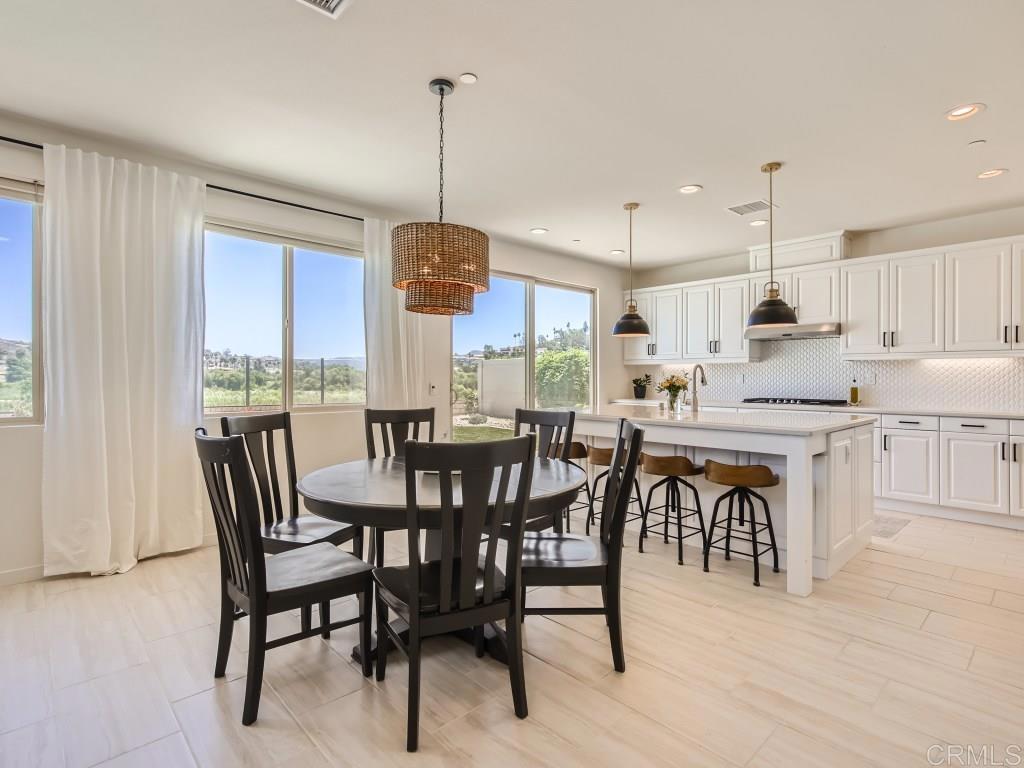 31657 Calle De Las Estrellas Bonsall, CA 92003 - Photo 4 of 24 a view of a dining room and livingroom with furniture wooden floor a chandelier