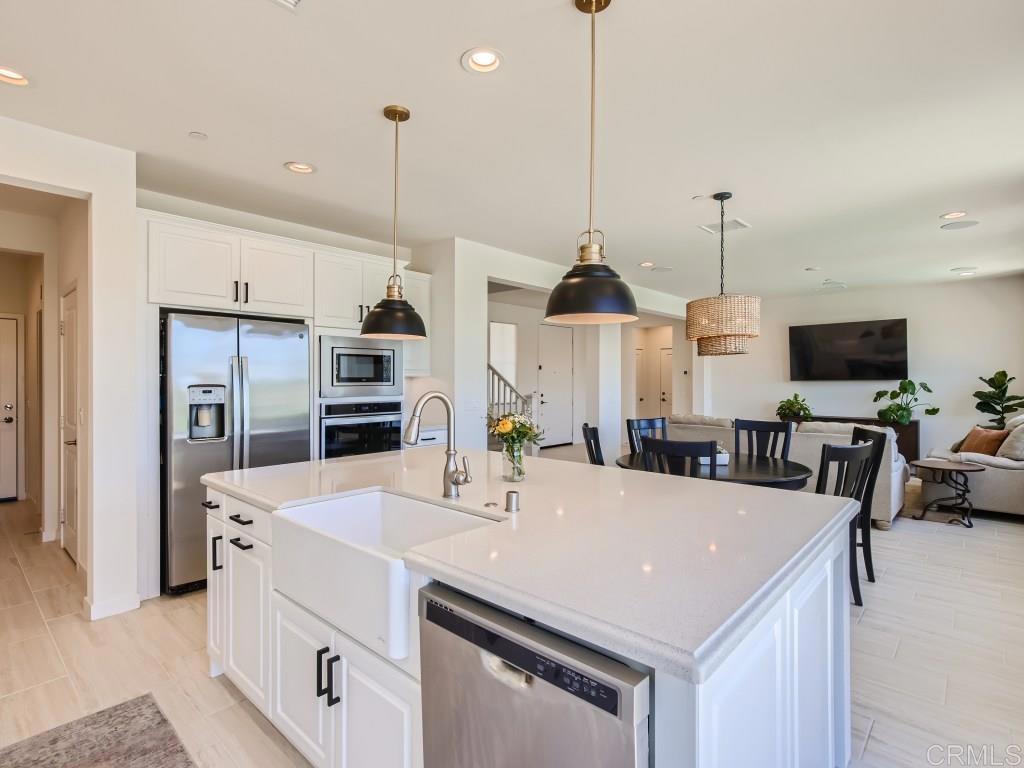 31657 Calle De Las Estrellas Bonsall, CA 92003 - Photo 6 of 24 a view of kitchen with stainless steel appliances kitchen island dining table and chairs