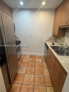9225 Southwest 87th Avenue, Unit A6 Miami, FL 33176 - Photo 4 of 16 a kitchen with a sink a counter top space and cabinets