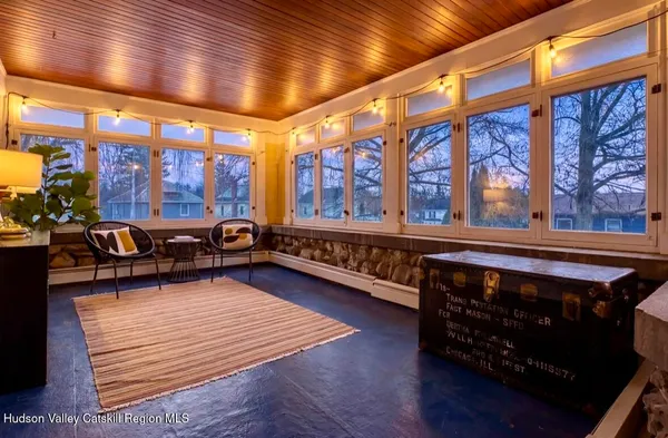 a living room with furniture a rug and a floor to ceiling window