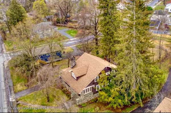 a brick house that has a small yard and a large tree in it