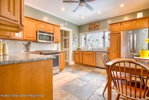 a large kitchen with stainless steel appliances granite countertop a stove a sink dishwasher a microwave oven with granite countertops and cabinets