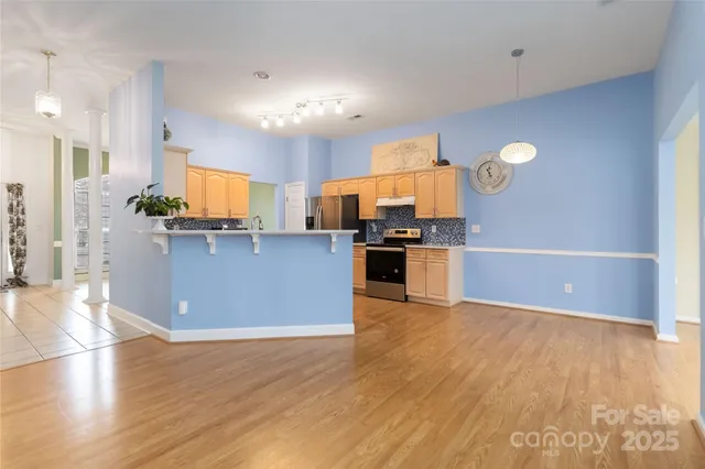 a kitchen with stainless steel appliances a refrigerator and a wooden floors