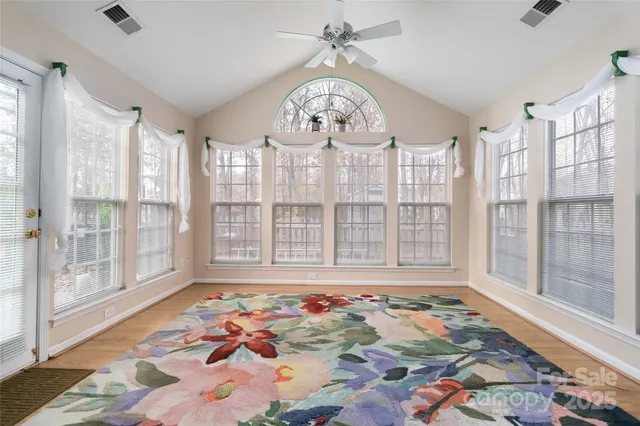 a view of an empty room with a chandelier fan