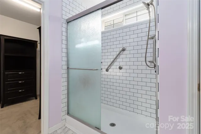 a view of an empty room with a window and hardwood floor