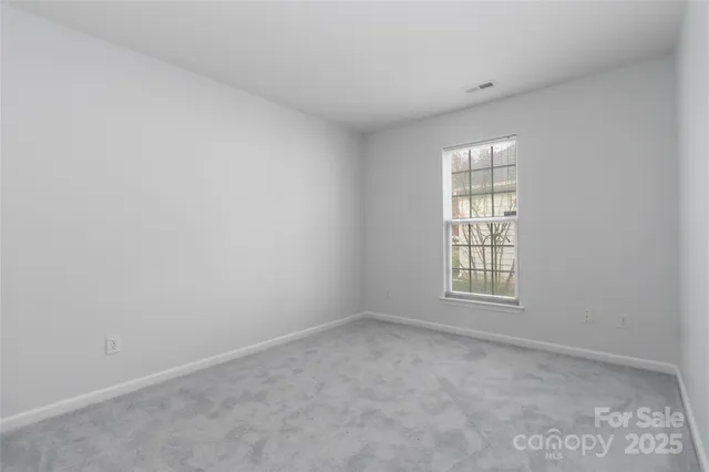 a front view of a house with a large tree