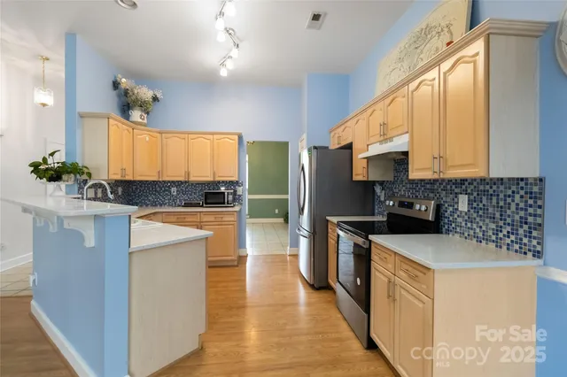 a kitchen with stainless steel appliances granite countertop a stove a sink and a refrigerator
