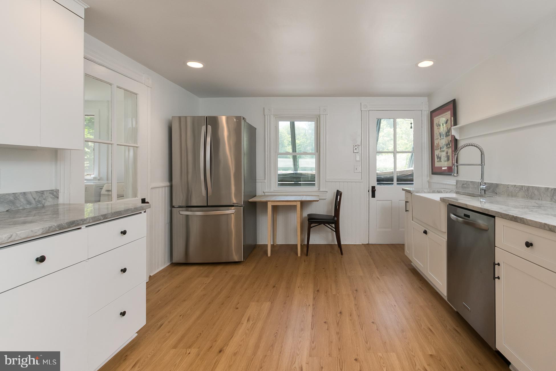 146 Carter Road Princeton, NJ 08540 - Photo 10 of 39 a kitchen with granite countertop a refrigerator a sink dishwasher a stove and white cabinets with wooden floor