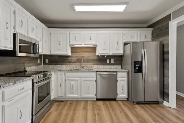 a kitchen with stainless steel appliances granite countertop a stove a refrigerator and a microwave