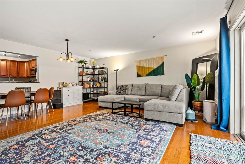 11 Cheriton Road, Unit 102 Boston, MA 02132 - Photo 16 of 42 a living room with furniture a rug and a bookshelf
