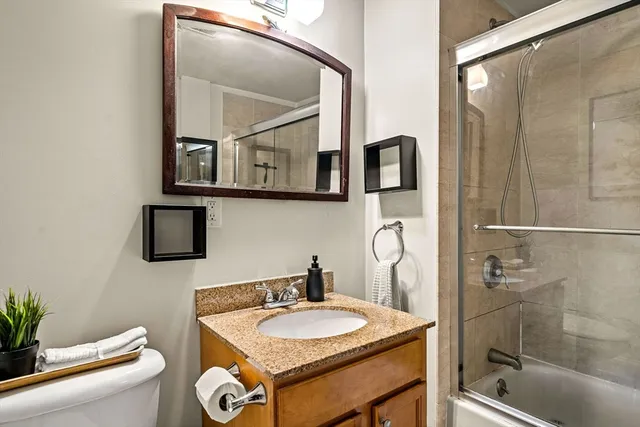 a bathroom with a sink a toilet and shower