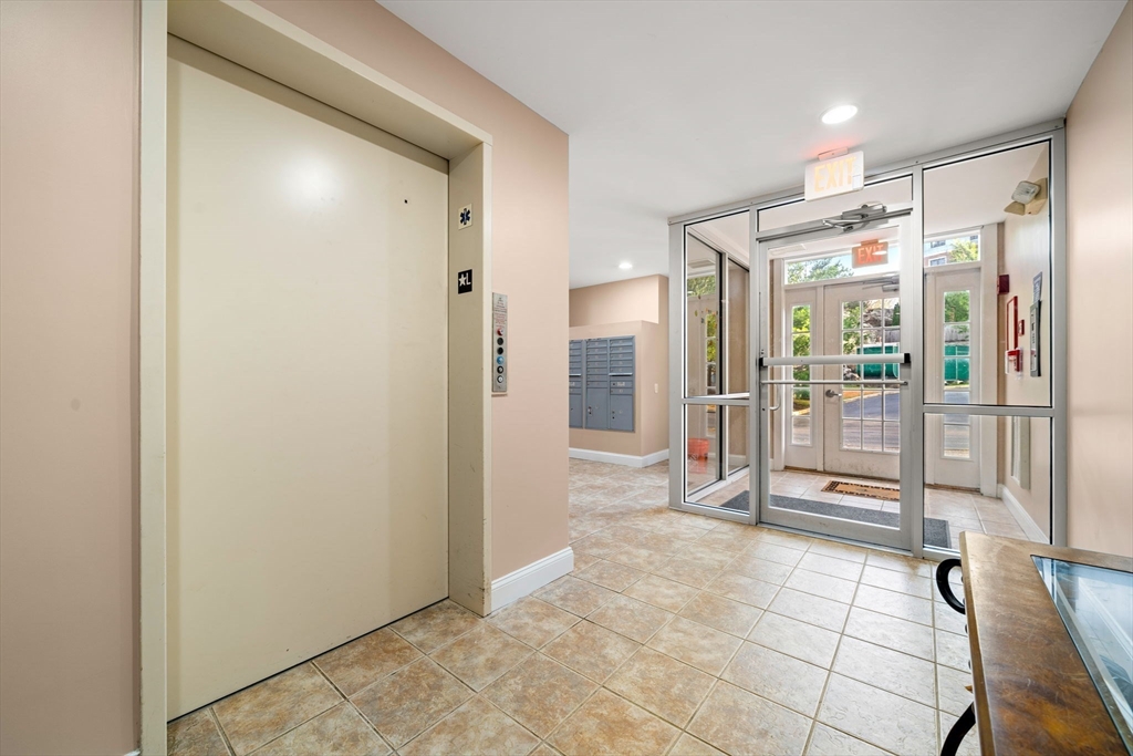 11 Cheriton Road, Unit 102 Boston, MA 02132 - Photo 29 of 42 a bathroom with a glass shower door and a mirror