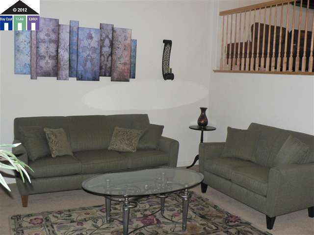 a living room with furniture a couch and kitchen view