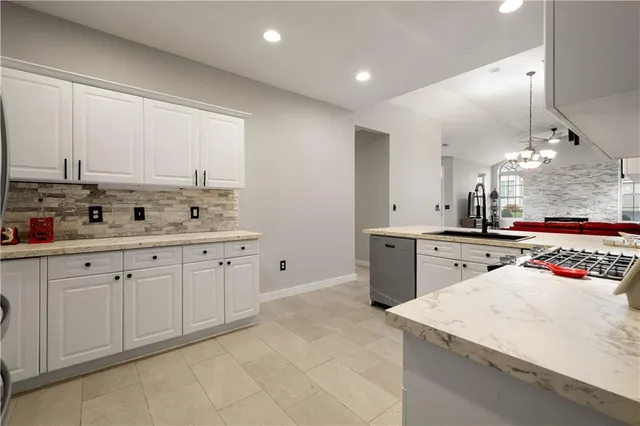a kitchen with stainless steel appliances granite countertop a sink and cabinets