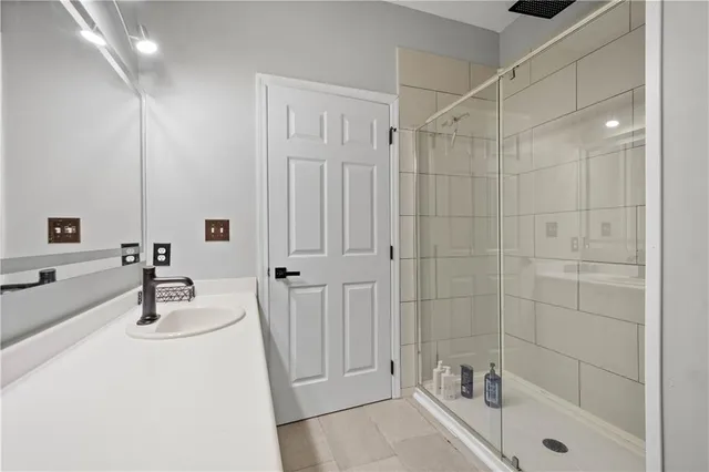 a bathroom with a tub a sink a mirror and shower